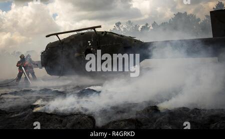 96Ala Test vigili del fuoco incendi di battaglia intorno a una simulazione di elicottero incidente durante un incidente di massa esercizio ottobre 3 a Eglin Air Force Base, Fla. Sistema comunitario di esercitare nel profondo della gamma Eglin compresi 96TW primi responder, 6 Ranger del battaglione di Formazione personale, Okala County primi responder tra gli altri. L'esercizio di valutazione azioni Ranger e la base e le risposte locali sia per la caduta di un fulmine e elicottero incidente. Foto Stock