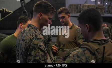 Marines con il trentunesimo Marine Expeditionary Unit Tie nodi durante la evacuazione medica della formazione a bordo della USS Green Bay (LPD 20) mentre è in corso nel Mar della Cina orientale, Sett. 21, 2018. Marines e marinai con il raid marittimo vigore potenziato la propria velocità e abilità per evacuazioni mediche. Il trentunesimo MEU, il Marine Corps' solo in modo continuo distribuita MEU, fornisce una forza flessibile pronto per eseguire una vasta gamma di operazioni militari. Foto Stock