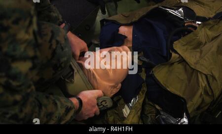 Un Marine con il trentunesimo Marine Expeditionary Unit colloca un casco su una simulazione di incidente durante l evacuazione medica della formazione a bordo della USS Green Bay (LPD 20) mentre è in corso nel Mar della Cina orientale, Sett. 21, 2018. Marines e marinai con il raid marittimo vigore potenziato la propria velocità e abilità per evacuazioni mediche. Il trentunesimo MEU, il Marine Corps' solo in modo continuo distribuita MEU, fornisce una forza flessibile pronto per eseguire una vasta gamma di operazioni militari. Foto Stock