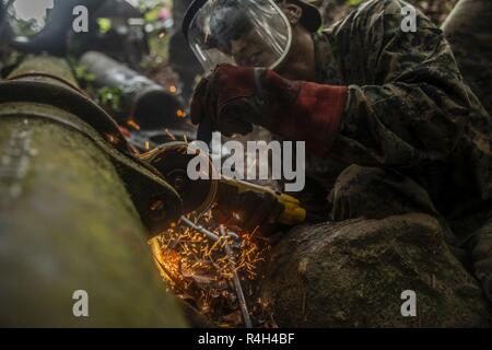 Stati Uniti Il personale marino Sgt. Immanuel Garcia, un lavoratore in metallo con scopi speciali Air-Ground Marine Task Force - Comando Sud (SPMAGTF-SC) inizia il taglio di sezioni di rottura di un tubo di acqua il Sep 19, 2018 in Trujillo, Honduras. La valvola dell'acqua è stato bloccato a 80% di intercettazione 6 effettuando la comunità locale contenente circa 8.000 persone. I marines riparato il tubo per l'acqua di ritorno per le comunità locali. I marines e i marinai di SPMAGTF-SC sono in conduzione la cooperazione in materia di sicurezza la formazione e i progetti di ingegneria a fianco di partner nazione le forze militari in America Centrale e America del Sud. L'unità è anche su s Foto Stock