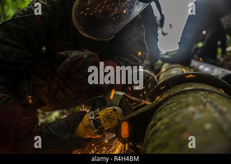 Stati Uniti Il personale marino Sgt. Immanuel Garcia, un lavoratore in metallo con scopi speciali Air-Ground Marine Task Force - Comando Sud (SPMAGTF-SC) inizia il taglio di sezioni di rottura di un tubo di acqua il Sep 19, 2018 in Trujillo, Honduras. La valvola dell'acqua è stato bloccato a 80% di intercettazione 6 effettuando la comunità locale contenente circa 8.000 persone. I marines riparato il tubo per l'acqua di ritorno per le comunità locali. I marines e i marinai di SPMAGTF-SC sono in conduzione la cooperazione in materia di sicurezza la formazione e i progetti di ingegneria a fianco di partner nazione le forze militari in America Centrale e America del Sud. L'unità è anche su s Foto Stock