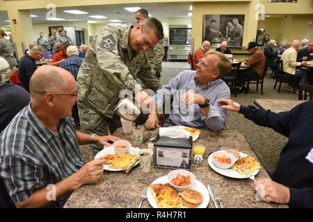 Stati Uniti Air Force Chief Master Sgt. Duane Kangas, 119a comando parafango chief, serve il caffè ai pensionati dei membri di unità presso il North Dakota Air National Guard Base, Fargo, N.D., Ottobre 3, 2018. L'ala 119a capo del Consiglio ospita ogni anno il breakfast get-insieme per pensionati elementi unitari ogni ottobre, come parte delle loro relazioni con la comunità programma. Circa 130 unità di ritentato i membri hanno partecipato all'evento. Foto Stock