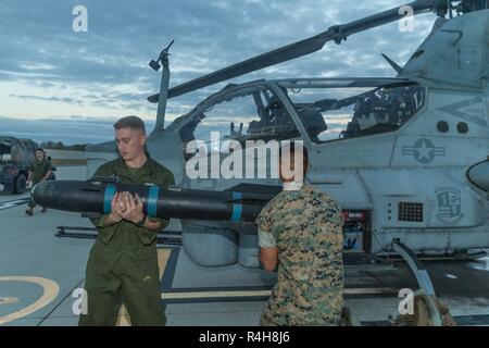 Stati Uniti Marine Corps Lance cpl. Kyle Adams (sinistra) e Marc Zepeda, aeromobili ordnance tecnico, Marine Attacco leggero elicottero Squadron 169, Marine Aircraft Group 39, terzo aeromobile Marina Wing, caricare un Captive Air-Training Missile su una campana AH-1Z Viper elicottero d'assalto al Marine Corps Air Station Camp Pendleton, California, Ottobre 2, 2018. Un aeromobile ordnance tecnico ha tra i suoi compiti quello di ispezione e il caricamento di munizioni, la riparazione di apparecchiature di armamento e di armamento o de-armamento aereo. Foto Stock