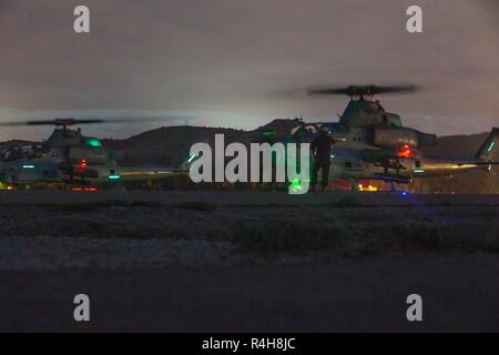 Stati Uniti Marines con Marine Attacco leggero elicottero Squadron 169, Marine Aircraft Group 39 (MAG-39), 3 aeromobili Marina Wing, condurre la finale dei controlli di sicurezza su due Bell AH-1Z Viper elicotteri da attacco, prima del decollo al Marine Corps Air Station Camp Pendleton, California, Ottobre 2, 2018. La missione di MAG-39 è di fornire utility supporto elicottero, vicino a supporto di fuoco, il fuoco di sostegno, di coordinamento e di una miriade di altre funzionalità di antenna durante la nave-shore movimento e successive operazioni di terra. Foto Stock