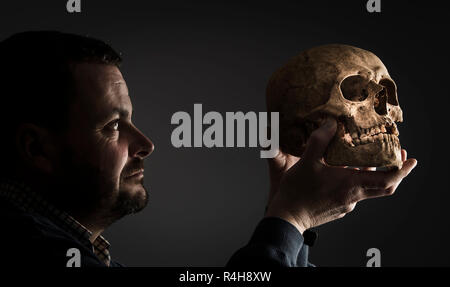 Dr Hugh Willmott, Senior Lecturer in unione Archeologia Storica dell'Università di Sheffield, detiene un teschio umano che è stato scoperto durante gli scavi presso un precedentemente sconosciuto cimitero anglosassone che dissotterrato sontuoso sepolture di donne con i loro gioielli e oggetti personali. Foto Stock