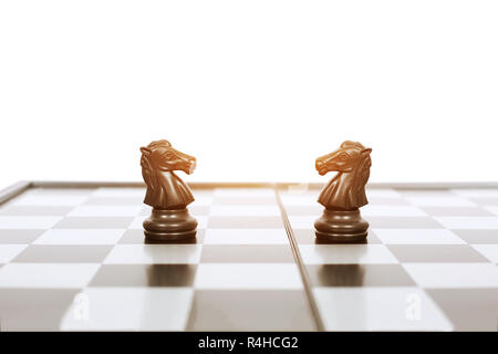 Immagine di nero a cavallo di due pedine di una scacchiera gioco. Isolato su uno sfondo bianco. Foto Stock