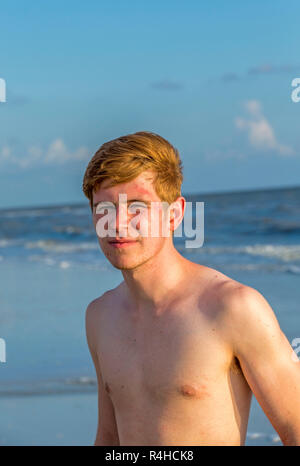 Bello fiducioso adolescente nel tramonto sulla spiaggia Foto Stock