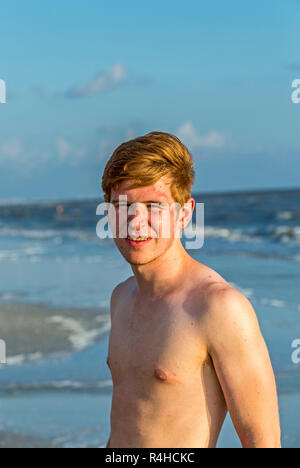 Bello fiducioso adolescente nel tramonto sulla spiaggia Foto Stock