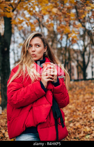 Donna in piedi in un parco con una bevanda calda, Bielorussia Foto Stock
