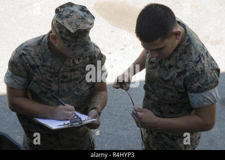 Stati Uniti Marine Corps Cpl. Jarrell Garcia (sinistra) e Cpl Luis Mendozamandujano, automobilistico di tecnici di manutenzione con il primo battaglione di Manutenzione, Logistica di combattimento del reggimento di 15, 1° Marine Logistics Group, riesaminare la qualità di controllo sul grafico a 7 ton di medie tattico di sostituzione del veicolo al Marine Corps base Camp Pendleton California, 26 ottobre, 2018. Il 7-ton è stato sottoposto a manutenzione di routine per garantire che il veicolo è stato cancellato per le operazioni di ogni giorno. Foto Stock