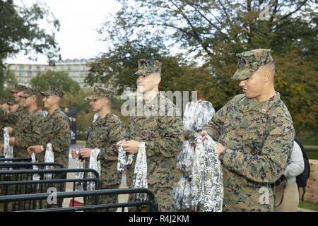 Stati Uniti Marine Corps ufficiali passano al di fuori delle medaglie ai partecipanti durante il Marine Corps Marathon al Marine Corps War Memorial, Arlington, Virginia, 28 ottobre 2018. Noto anche come "popolo della maratona,' il 26,2 miglia race ha attirato circa 30.000 partecipanti per promuovere il benessere fisico, generare la buona volontà nella comunità e mostrare la capacità organizzativa del Marine Corps. Foto Stock