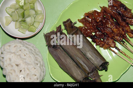 Piatto di riso dolci (lontong) con saté bastoni. Foto Stock