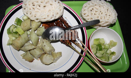 Piatto di riso dolci (lontong) con saté bastoni. Foto Stock