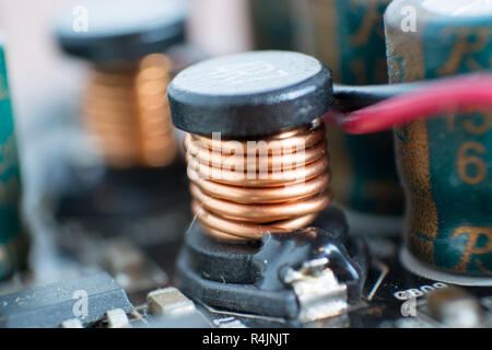Condensatore elettrolitico e conduttore visibile sulla scheda a circuito stampato. Foto Stock