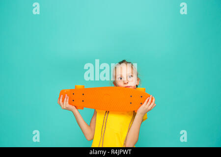 Graziosa fanciulla skater holding skateboard Foto Stock