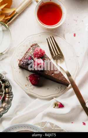 Cheesecake al cioccolato con lamponi su una piastra bianca Foto Stock