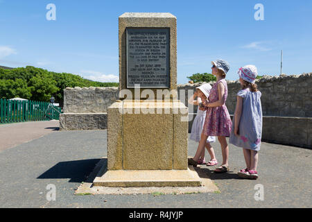 Bambini / ragazzi / ragazze leggere le varie placche sulla Marconi monumento di aghi Landmark Attraction Park sull'Isola di Wight, Regno Unito. (98) Foto Stock