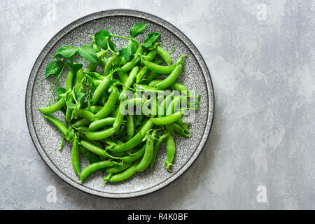 Appena raccolte di zucchero organico piselli a scatto su una piastra. Foto Stock