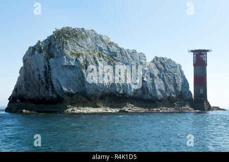 Gli aghi e il suo faro su una soleggiata giornata d'estate con cielo azzurro e sole. Isola di Wight. Regno Unito. Visto da un turista imbarcazione da diporto in allume Bay. (98) Foto Stock