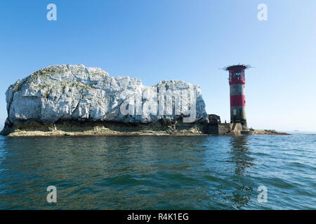 Gli aghi e il suo faro su una soleggiata giornata d'estate con cielo azzurro e sole. Isola di Wight. Regno Unito. Visto da un turista imbarcazione da diporto in allume Bay. (98) Foto Stock