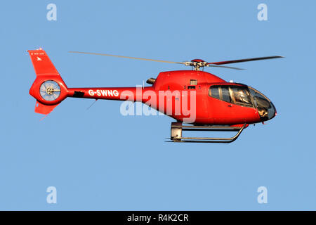 Elicottero rosso contro un cielo blu Foto Stock