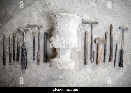 Scultore strumenti di lavoro con il vecchio vaso sul pavimento Foto Stock