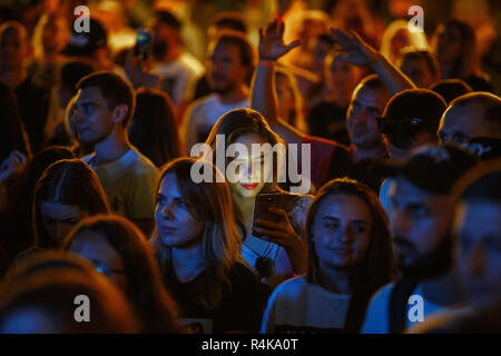 KIEV-11 luglio,2018: ragazza studente utilizza lo smartphone sulla pista da ballo presso i festival estivi di musica Bazar. Giovane donna utilizza moderne cellulare in grande folla a c Foto Stock