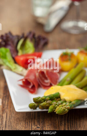 Asparagi verdi con salsa hollandaise su una piastra Foto Stock