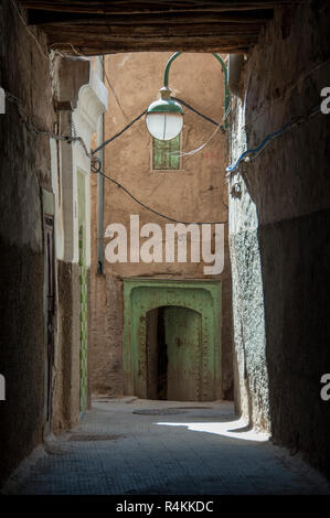 18-04-11. Marrakech, Marocco. Nella medina e una vista verso il basso una lampada accesa vicolo, per un'antica porta / ingresso a una casa. Foto © Simon Grosset Foto Stock