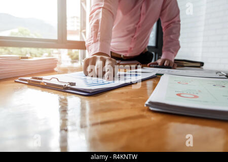 Imprenditore di puntamento grafico mensile grafico. Analizzando i dati per scoprire il risultato. Foto Stock