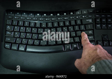 Man digitando su una tastiera con lettere in ebraico e in inglese Foto Stock