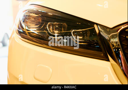 Fari di automobile di nuove auto moderna. gialla toni caldi. closeup Foto Stock