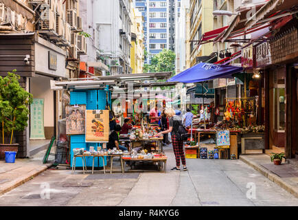 I turisti a fare shopping lungo superiore fila Lascar, comunemente noto come Cat St in Hong Kong Foto Stock