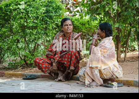 Due donna indiana sedersi per terra e parla. 8 febbraio 2018 Sai Baba Ashram Puttaparthi Foto Stock