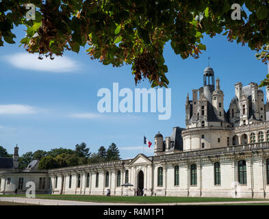 Ampio angolo di visione di Chateau de Chambord ingresso con bandiera francese sulla parte superiore, lo spazio negativo nel cielo. Foto Stock