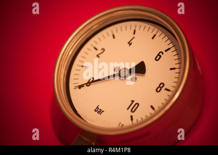 Manometro su sfondo rosso Foto Stock