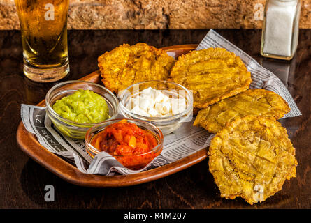 Patacones o tostones (frittelle di platano) sono verdi fritti fette di piantaggine, realizzata con il verde delle banane da cuocere. Cibo Tipico da Messico e America del Sud. Foto Stock