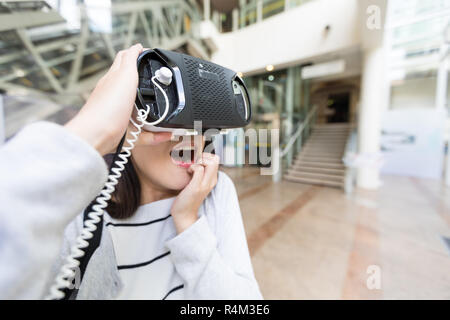 Sentimento donna paura quando si utilizzando la realtà virtuale nel centro commerciale per lo shopping Foto Stock