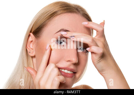 Giovane donna contatto holding lente sul dito indice con copia spazio. Vicino la faccia del sano bella donna circa di indossare lenti a contatto. La vista e l'op Foto Stock