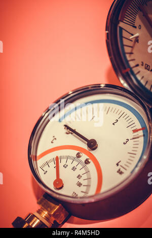 Manometro su sfondo rosso Foto Stock