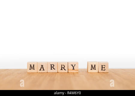 Focus sulla frase 'Marry Me' fatta di blocco di legno dice con lettere su una tavola di legno. Profondità di campo. Copia dello spazio. Foto Stock