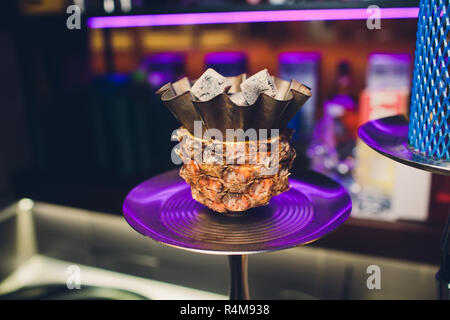 Shisha con coppa di frutta con fumo colorato in Hookah Bar Closeup. Foto Stock