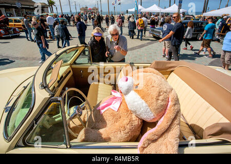 Un 1953 Plymouth Cranbrook con un gigante bunny al volante saluta classico gli appassionati di auto al molo di Huntington Beach, CA. Foto Stock