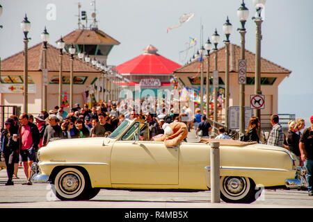 Un 1953 Plymouth Cranbrook con un gigante bunny al volante saluta classico gli appassionati di auto al molo di Huntington Beach, CA. Foto Stock