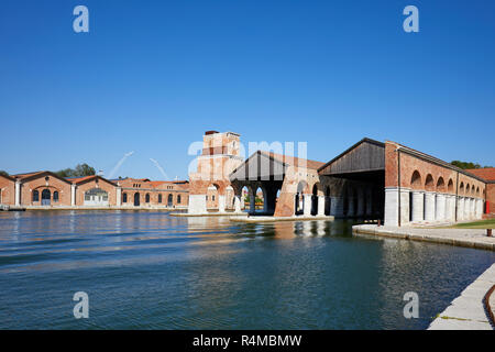 Arsenale veneziano con dock, canal e edificio industriale in una giornata di sole a Venezia, Italia Foto Stock