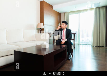 Businessman cinesi in viaggio d'affari in hotel suite Foto Stock