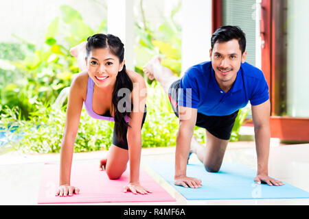 Asian l uomo e la donna in esercizio di fitness in casa Foto Stock