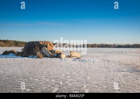 Vista su un congelato lago di cava in una soleggiata giornata invernale. Foto Stock