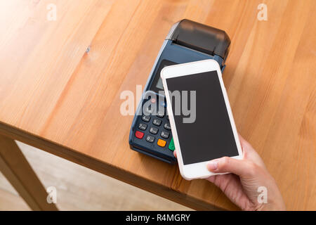 Cellulare pagare sulla macchina pos Foto Stock