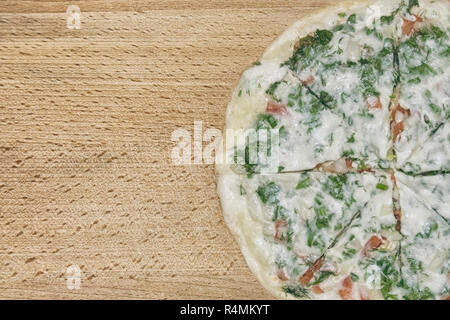 Il taglio pizza giace su una tavola di legno texture di sfondo Foto Stock